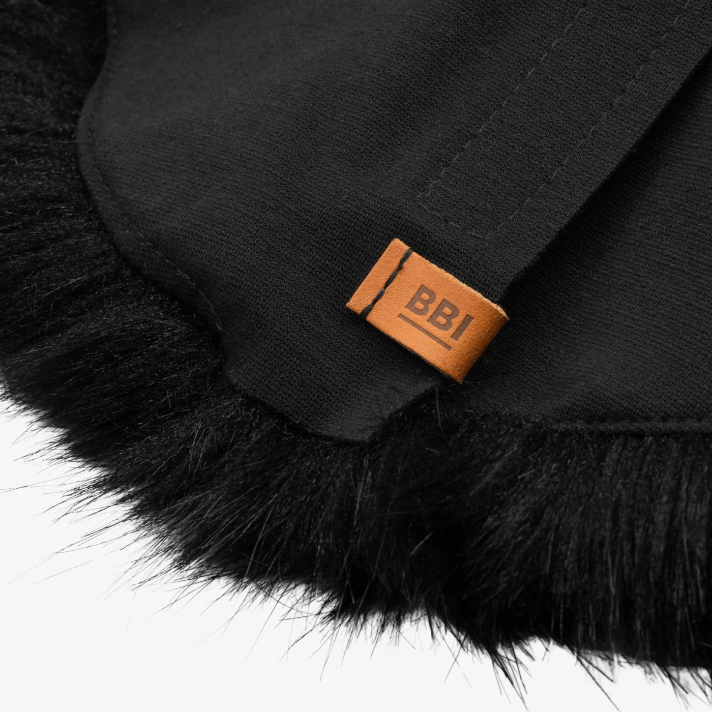 Black faux-fur microphone windscreen close-up with orange "BBI" label on fabric