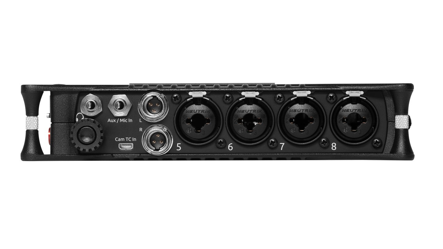 Black audio mixer rear edge with multiple port groups and knobs