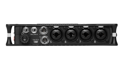 Black audio mixer rear edge with multiple port groups and knobs