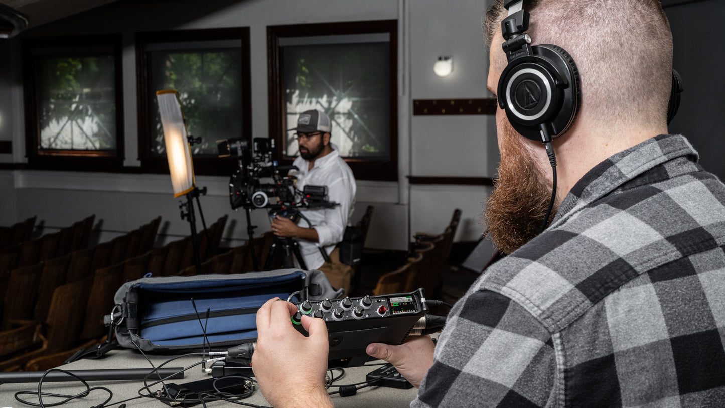 Audio mixer being operated by a person wearing headphones during recording