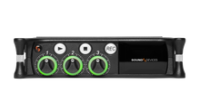 Front view of black portable audio recorder/interface with green level knobs and display.