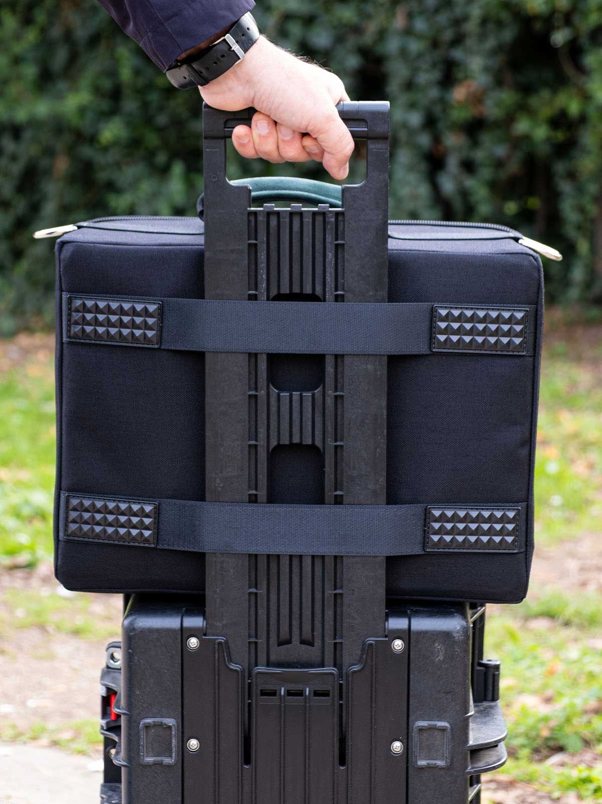 Black accessory organizer case with reinforced strap carry handle and webbing panels.