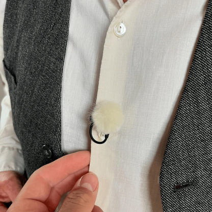 Light jacket with fuzzy windscreen pom-pom on a black cord clip