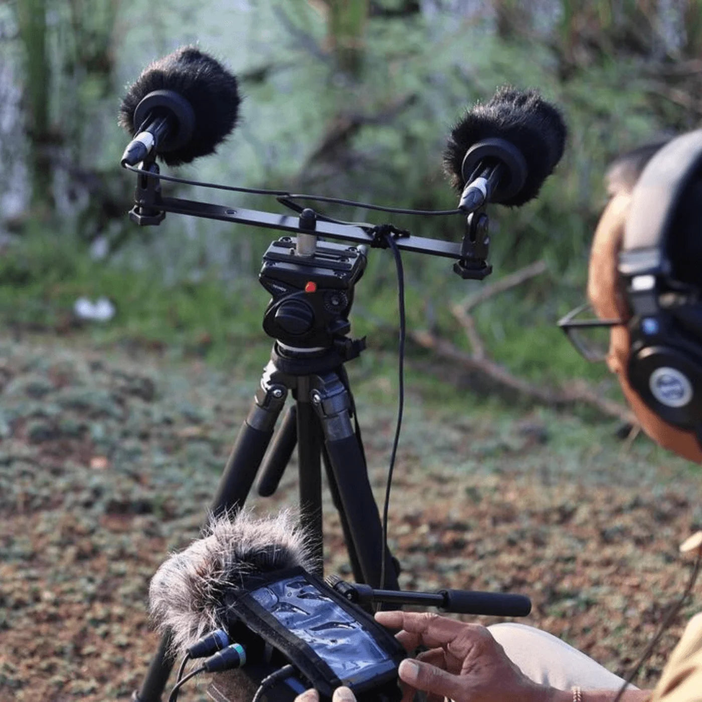 Black furry microphone windscreen on camera-mounted shotgun mic with foam cover