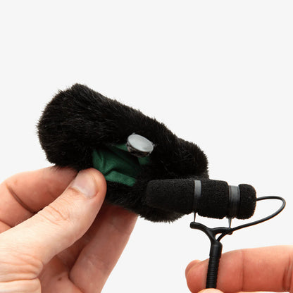 Black furry windscreen with green inner insert, held in hand for DPA