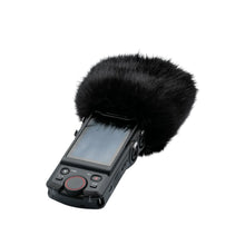 Black handheld recorder with attached black furry windscreen cover