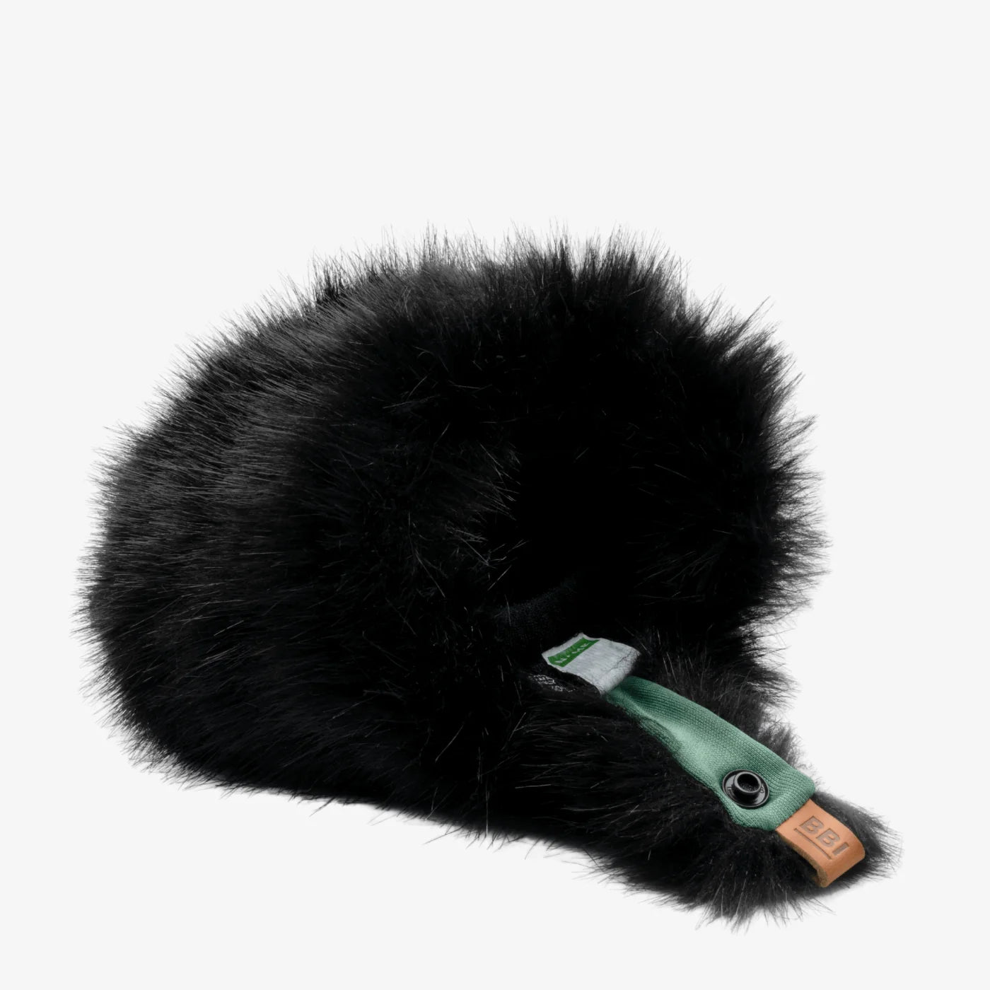 Black furry microphone windscreen with green mounting strap and label detail