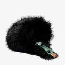 Black furry microphone windscreen with green mounting strap and label detail