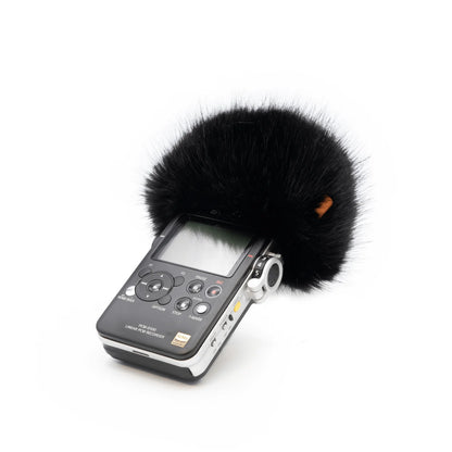 Handheld audio recorder with black furry windscreen and side controls